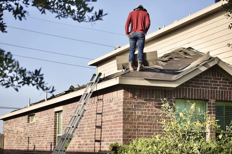 Professional roofer working on a residential roof in Gratis